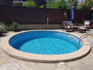a swimming pool in a backyard with a table and chairs at Villa Raya in Sozopol