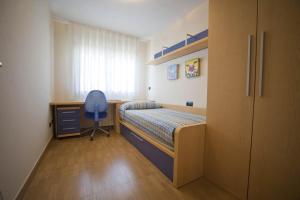 1 dormitorio con cama, escritorio y silla en Apartamentos Turísticos Vicotel, en Teruel