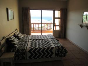 um quarto com uma cama e vista para o oceano em Uberkei em Coffee Bay