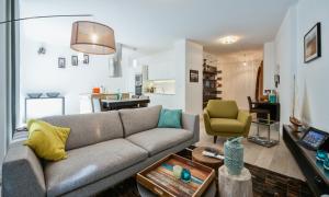 - un salon avec un canapé et une chaise dans l'établissement Appartement Le Venise, à Annecy