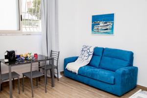 un salon avec un canapé bleu et une table dans l'établissement La Posento, à Alghero 15 autres photos