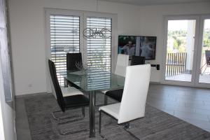 comedor con mesa de cristal y sillas en Salvatorferienwohnung, en Schwäbisch Gmünd