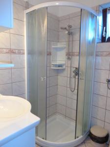 um chuveiro com uma porta de vidro na casa de banho em I & S Apartments em Vodice
