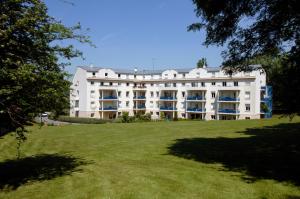 un gran edificio blanco en un campo de hierba en Residence Hotel Les Ducs De Chevreuse avec Parking, Hébergement, Repas & PDJ, en Chevreuse