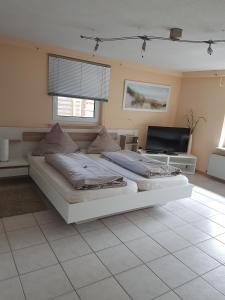 ein Schlafzimmer mit einem großen weißen Bett und einem TV in der Unterkunft Ferienwohnung Ulmrich in Kesselbach