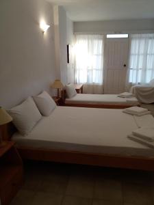 a bedroom with two beds and a window at Apaggio Apartments in Katapola +66 photos