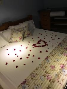 Una cama con corazones y flores. en Fazenda Mantiqueira e Restaurante en Camanducaia