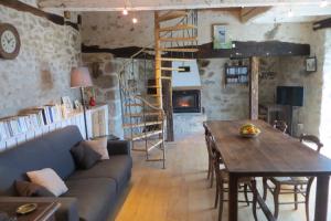 a living room with a couch and a wooden table at Gîte de La Porte in Eygurande