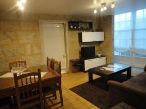 a living room with a table and a dining room at Dúplex OS BATANS in Laxe