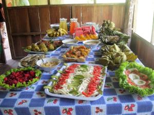 a table with a blue table cloth with different types of food at Lodge Jungle Wolf Expeditions in Yucuruche