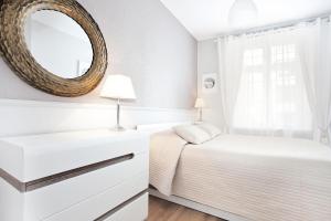 um quarto com uma cama e um espelho na parede em The Heart of Old Town Apartments em Gdansk