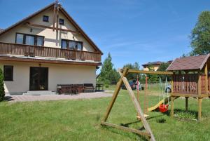 um parque infantil num quintal com uma casa em Ostrowo Morza Brzeg em Ostrowo