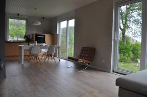 sala de estar con mesa, sillas y ventanas en Hei og Hav - i Torbjørn Egners Ferierike en Mandal