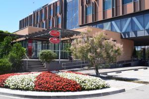 a building with a flower bed in front of a building at Safir Hotel Casino in Sežana