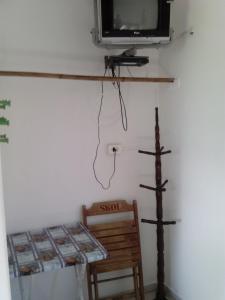 a room with a tv and a cross on the wall at Hotel Pousada Guaratuba in Guaratuba