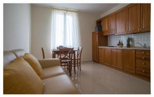 uma sala de estar com um sofá e uma cozinha com uma mesa em Lido Resort em Finale Ligure