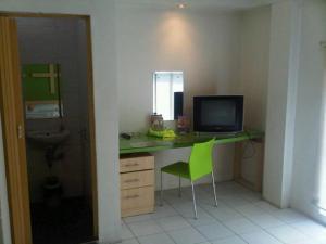 a room with a desk with a computer and a green chair at Sabrina Paninsula in Pekanbaru