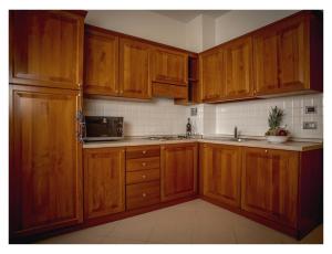 una cocina con armarios de madera y fregadero en Lido Resort, en Finale Ligure