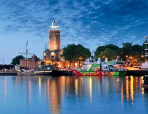 a group of boats docked in a harbor with a lighthouse at Apartament Ogrody in Kołobrzeg