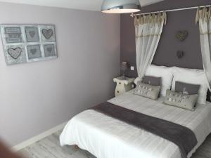 1 dormitorio con 1 cama con sábanas y almohadas blancas en Mes Ptits Apparts en La Cotinière