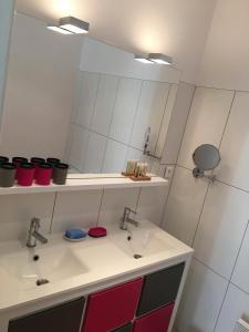 baño con 2 lavabos y espejo grande en Mes Ptits Apparts, en La Cotinière