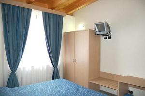 um quarto com uma cama e uma televisão na parede em Mare Blu em Gioiosa Marea