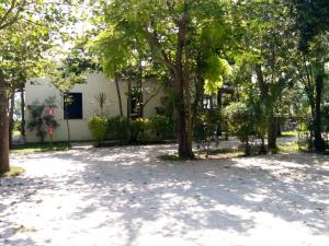 un parque con árboles y un edificio blanco en Lido Villaggio il Ragno, en Minturno