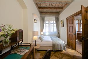 a bedroom with a bed and a desk and a window at Residence U Mecenáše in Prague