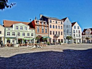 a group of buildings on a cobblestone street at Ferienwohnung Am Ueckerpark in Ueckermünde
