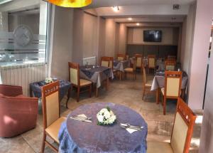 een eetkamer met tafels en stoelen en een tv bij Hotel Anita in Budva