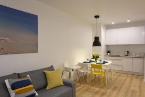 a living room with a couch and a table with chairs at Dwie Sosny Apartamenty Ostrowski in Ustronie Morskie