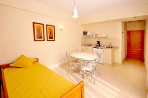 a bedroom with a bed and a table and a kitchen at Orion Apartamentos in Bahía Blanca