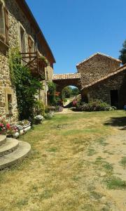 a stone building with an archway in a yard at Gîtes de Lez in Laguépie