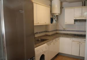 a kitchen with white cabinets and a sink at Azucena in Garrucha