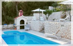 a swimming pool with a bird house next to a wall at Apartment with pool near Split in Split