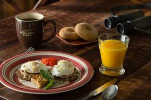 un plato de comida con huevos en una mesa con un vaso de zumo de naranja en Eagle Rock Lodge, en Vida