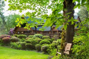 a bench in a garden with a house in the background at Eagle Rock Lodge in Vida