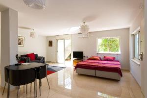 a bedroom with a bed and a living room at Magnificent studio in Zichron yaakov sea view and garden in Zikhron Ya'akov