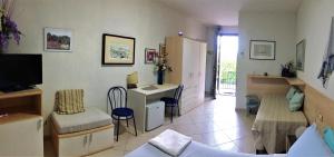uma sala de estar com uma secretária e um quarto com um sofá em I Girasoli di Migliarino em Migliarino