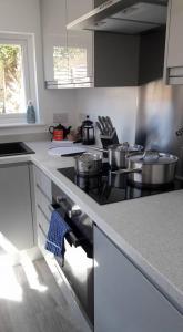 a kitchen with a stove with pots and pans at Wolds Cottage Pocklington in Pocklington