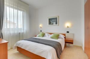 a bedroom with a large bed and a window at Villa NiNa B&B Rovinj in Rovinj