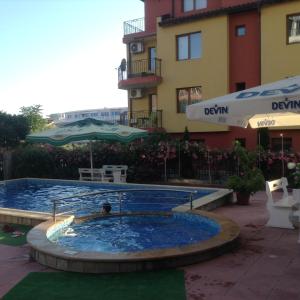 a swimming pool in front of a building at Studio Mirazh in Nesebar