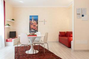 Apartment Home Marconi25 في فيرونا: غرفة معيشة مع طاولة وكراسي وأريكة