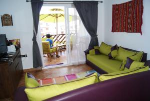 sala de estar con sofá verde y patio en Appartement Miradorgolf, en Cabo Negro