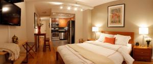 a bedroom with a large bed and a kitchen at Sanctuary NYC Retreats in New York