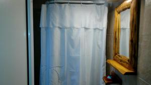 a white shower curtain in a bathroom next to a mirror at Departamentos de Alquiler Turistico: Familia Eguren in San Carlos de Bariloche +44 photos
