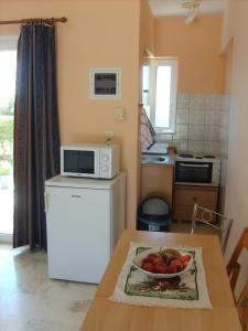 a kitchen with a table with a bowl of fruit on it at Gouna's Aparts in Xi