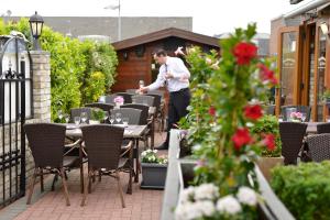 a man standing in a patio with tables and chairs at Hotel zur Post Kleve in Kleve +31 photos