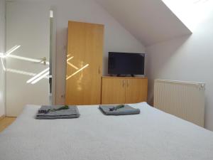a bedroom with a bed with two towels on it at Albízia Apartments in Balatonfüred