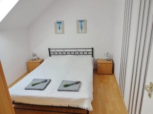 a bedroom with a bed with two towels on it at Albízia Apartments in Balatonfüred